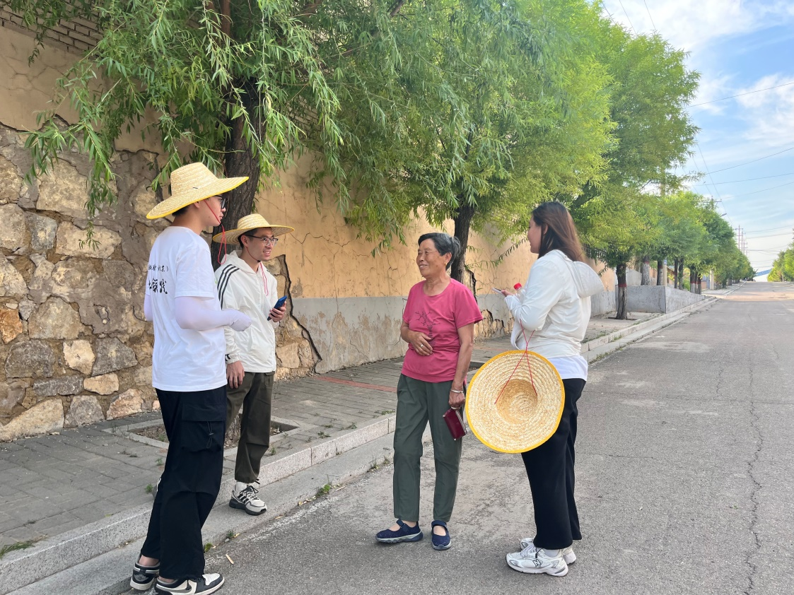 國(guó)土整治與生態(tài)修復(fù)實(shí)踐調(diào)研團(tuán)師生與村民交流。校方供圖